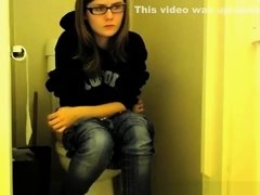 Girl in glasses pees in bathroom toilet